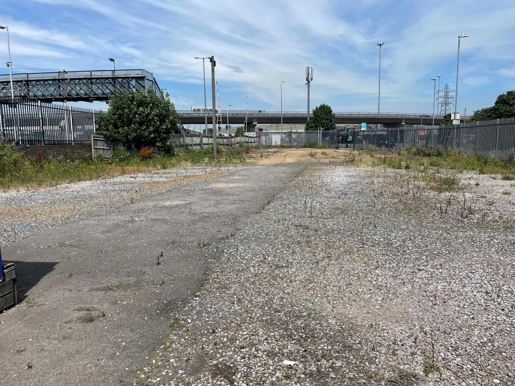 Lot: 99 - LAND WITH RESIDENTIAL PLANNING FOR 33 UNITS - View of site to south with fencing and hardstanding area